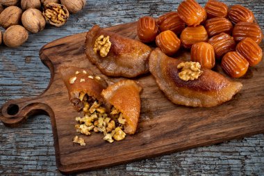 Tulumba tatlisi or bamiyeh dessert and tas kadayif or atayef on the table at ramadan dinner. Desert concept with local foods. 