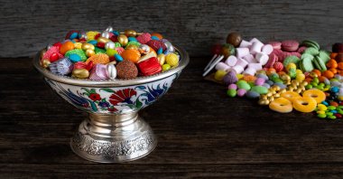Tahta masada bir kase şeker ve çikolata. Çok çeşit şeker.. 