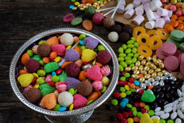 Tahta masada bir kase şeker ve çikolata. Çok çeşit şeker.. 