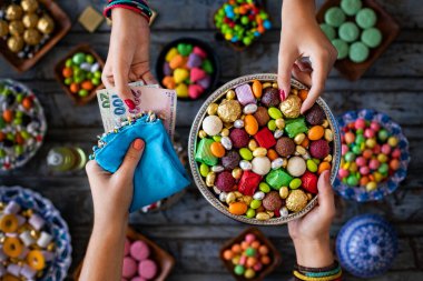 Bowl of candies and chocolate at the hands of two women