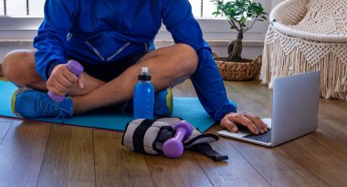 Çevrimiçi fitness dersleriyle evde egzersiz yapmak. Video dersi izliyor ve oturma odasında egzersiz yapıyor.. 
