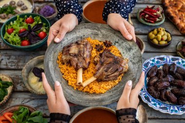 İftar, kutsal Ramazan 'da ailenle birlikte oruç tut, iftar zamanı yemek masasının en üst görüntüsü, pek çok insan eli yemeğini paylaştığında..