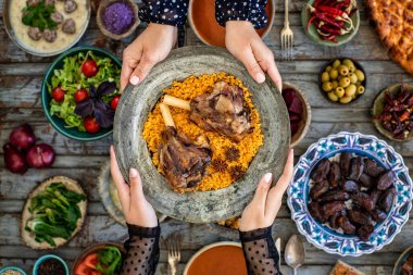 İftar, kutsal Ramazan 'da ailenle birlikte oruç tut, iftar zamanı yemek masasının en üst görüntüsü, pek çok insan eli yemeğini paylaştığında..