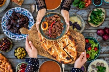 İftar, kutsal Ramazan 'da ailenle birlikte oruç tut, iftar zamanı yemek masasının en üst görüntüsü, pek çok insan eli yemeğini paylaştığında..