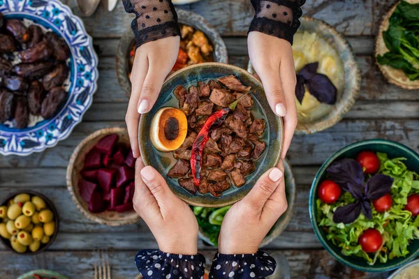 İftar, kutsal Ramazan 'da ailenle birlikte oruç tut, iftar zamanı yemek masasının en üst görüntüsü, pek çok insan eli yemeğini paylaştığında..