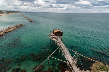 Antik Termoli köyünün eteklerinde, Trabucchi 'nin gezinti güvertesi, kıyıların çeşitli trabucchi veya 19. yüzyıla kadar uzanan balıkçılık makinelerine erişebileceğiniz bir kısmına doğru esiyor. İlk trabucco. 