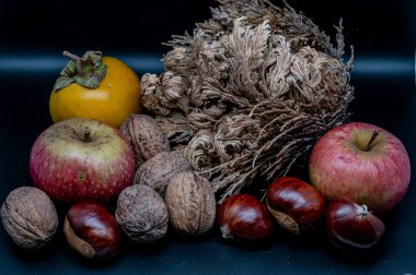 A composition of typically autumnal fruits such as chestnuts, walnuts, persimmons or the Campanian Annurca apple, enhancing their beauty and detail.