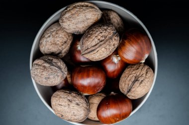 A composition of typically autumnal fruits such as chestnuts and walnuts, enhancing their beauty and detail.