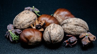 A composition of typically autumnal fruits such as chestnuts and walnuts, enhancing their beauty and detail.