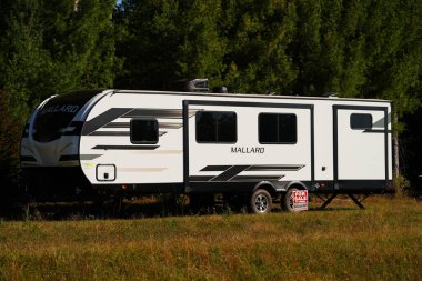 Beyaz karavan ormanın ortasında duruyor..