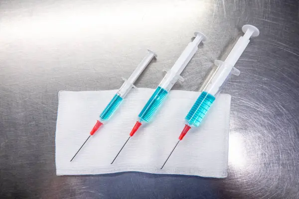 Tři Různě Velké Injekční Stříkačky Naplněné Modrou Tekutinou Leží Bílém — Stock fotografie