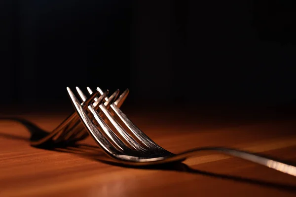 Wooden Plate Two Silver Forks Inserted Each Other — Stock Photo, Image