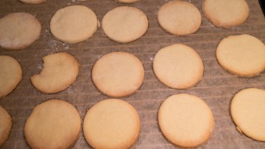 Pişirme tepsisinde hazır hafif kurabiyeler var.