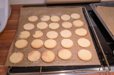 Pişirme tepsisinde hazır hafif kurabiyeler var.