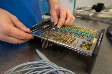 Farklı titanyum cerrahi vidalar boyutlarına ve tiplerine göre bir tepside sıralanır.