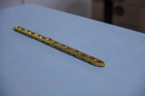 Una Lastra Titanio Chirurgico Color Oro Spiegata Trova Tavolo Operatorio — Foto Stock
