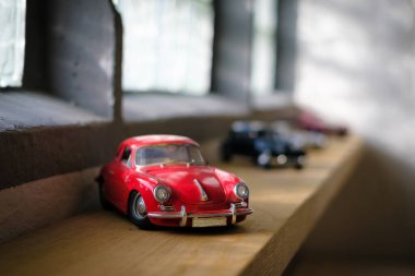 Pencerenin kenarında birkaç eski model araba var.