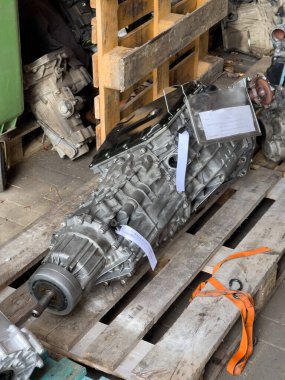 Tamir edilmiş motor vites kutuları ahşap paletlerin üzerinde duruyor.