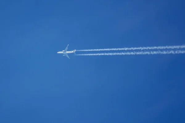 Avión Blanco Vuela Cielo Azul Sin Nubes Arrastrando Senderos Vapor —  Fotos de Stock