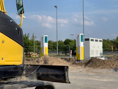 Elektrikli araçlar için şarj sütunları bir benzin istasyonunun binasına kurulur