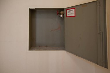 İtfaiye için bir yangın musluğu duvardaki metal bir kapının arkasında. 