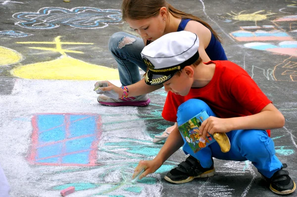 Boy and girl paint on asphalt — Stock Photo, Image