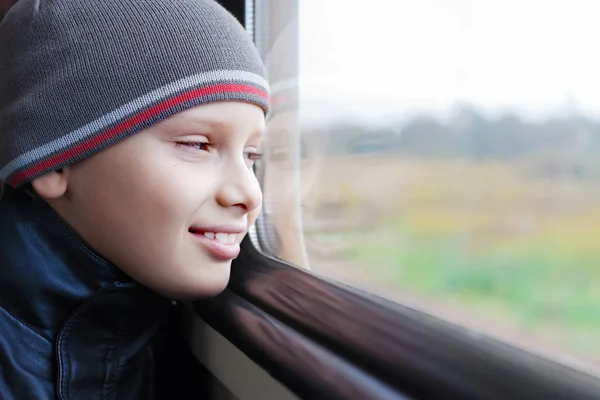 Dítě roztomilý úsměv vlak vzhled okna cestování — Stock fotografie