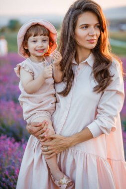 Anne, gün batımında lavanta tarlasında kızını kucaklıyor..