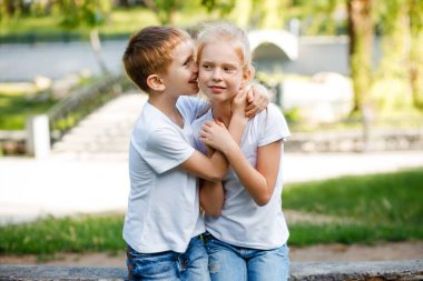 Çocuk kızların kulağına bir sır fısıldıyor. Çocuklar parkta yürüyüşe çıktı..