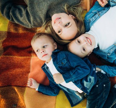 Mutlu bir aile gülümsüyor ve yukarı bakıyor. Aile piknikte.