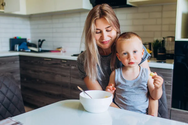 Morgonfrukost med barnet. Mor matar barnet med frukost. — Stockfoto