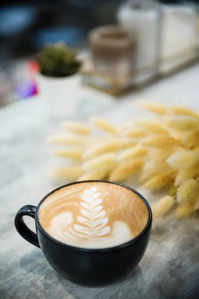 Cup of cappuccino with a pattern on a wooden table. — Stock Photo, Image