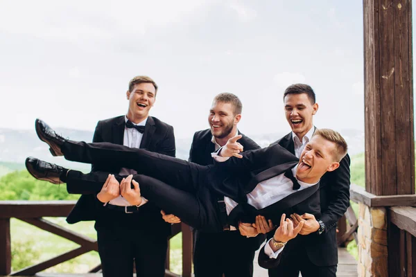 Pan młody i jego przyjaciele świętują ślub. Mężczyźni w garniturach. Emocje męskie i przyjaźń. — Zdjęcie stockowe