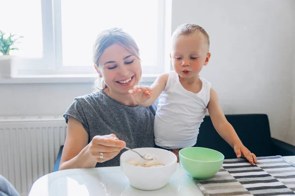 Morgonfrukost med barnet. Mor matar barnet med frukost. — Stockfoto