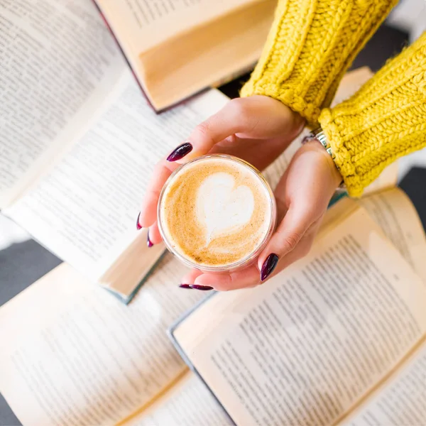 Morning coffee with a pattern on the background of books. — Stock Photo, Image