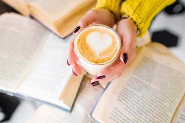 Morning coffee with a pattern on the background of books. — Stock Photo, Image