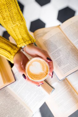 Sabah kahvesi ve arka planda kitaplar..