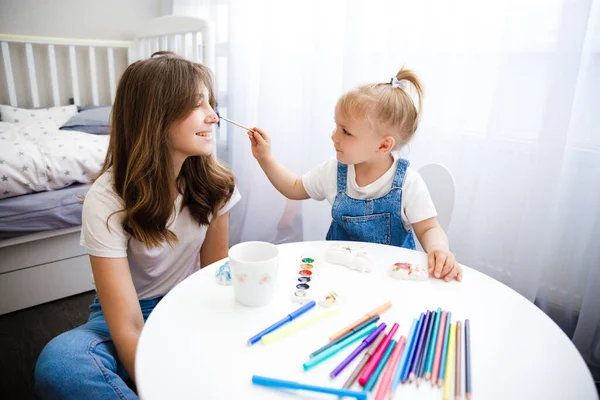 Anya és lánya együtt festenek. A gyermek az anyjával rajzol.. — Stock Fotó
