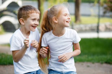 Neşeli çocuklar parkta yeşil bankta oynuyorlar..