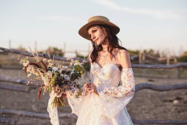 Çiftlikte boho tarzında bir düğün çifti. Tasarımcı düğün buketi.