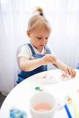 Anne ve kızı birlikte resim yapıyorlar. Çocuk annesiyle resim çiziyor..