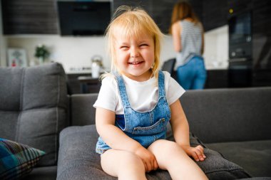 Küçük kız annesinin yanında gülüyor.. 