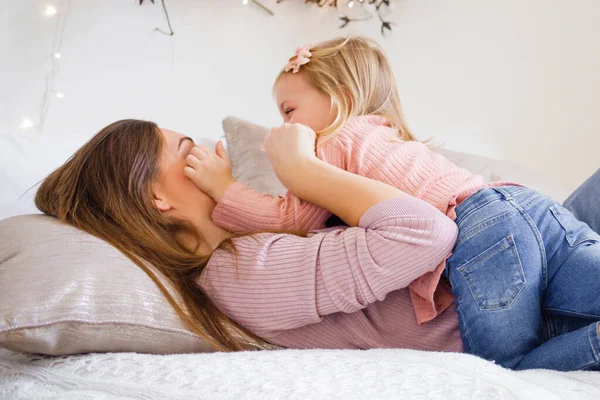 Mor leker med sin dotter på sängen. — Stockfoto