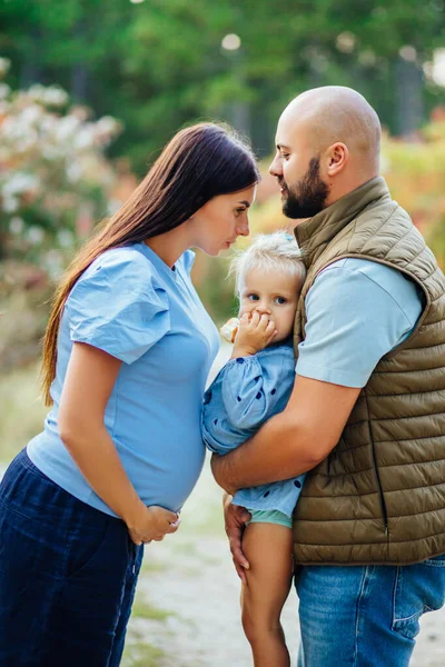 Den unga familjen väntar sitt andra barn. — Stockfoto
