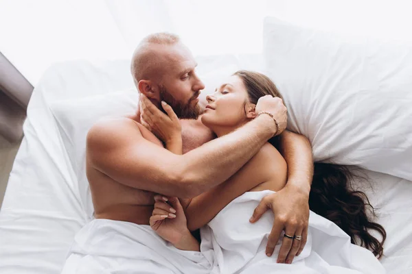 O casal está a abraçar-se na cama. Relação tradicional. — Fotografia de Stock