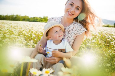 Anne ve oğlu yeşil bir çayırda oynuyorlar.. 