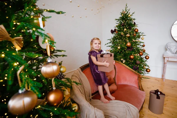 Little blondynka dziewczyna otoczony przez prezenty świąteczne. — Zdjęcie stockowe