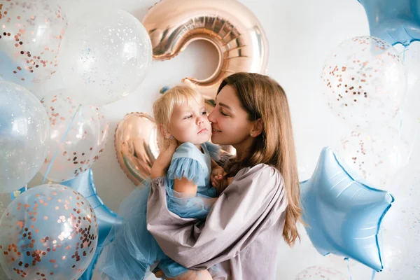 Mor och dotter firar sin födelsedag i vackra klänningar med ballonger. — Stockfoto