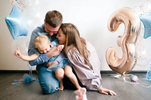 Familjen firar sin lilla dotters födelsedag. Födelsedag firande i blå klänningar och ballonger. — Stockfoto