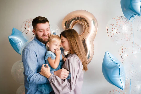 Familjen firar sin lilla dotters födelsedag. Födelsedag firande i blå klänningar och ballonger. — Stockfoto